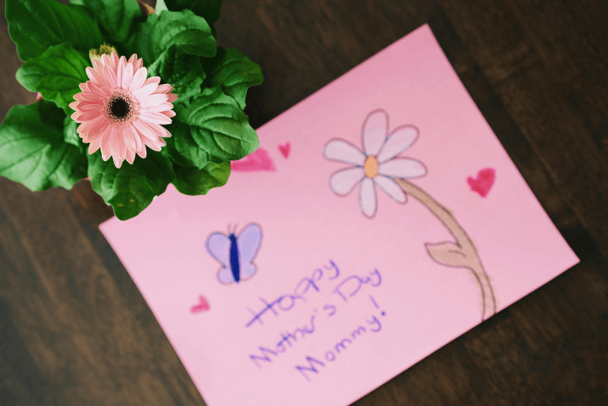 a gerbara daisy and a handwritten Mother's Day card